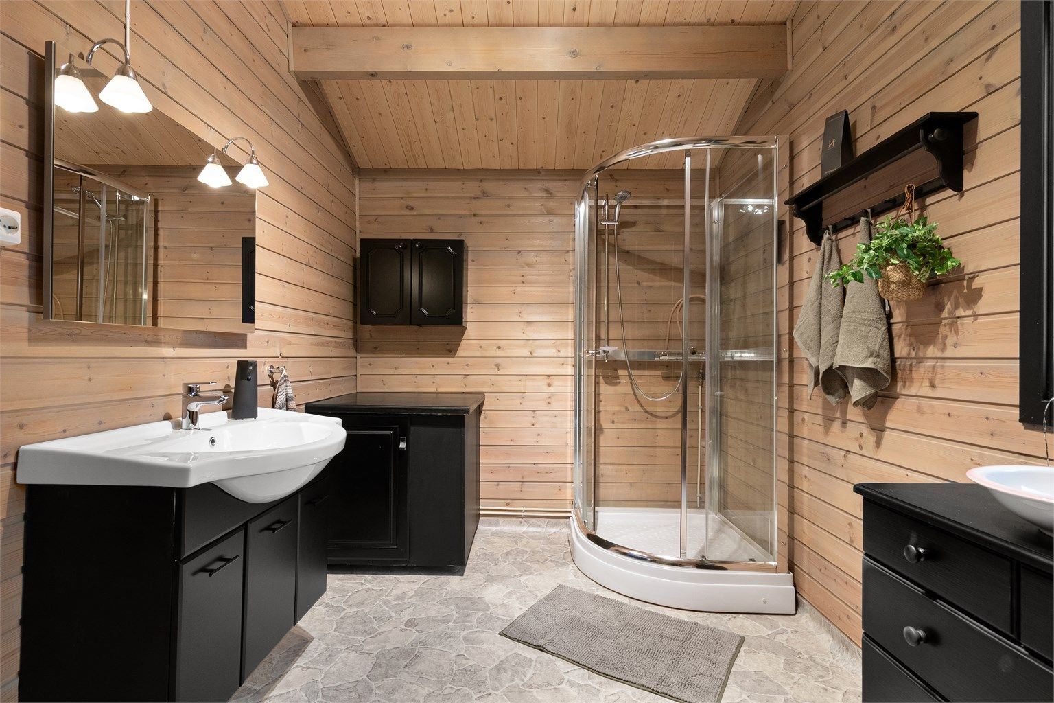 Baderommet er utstyrt med dusjkabinett og servantinnredning med speil og overlys.