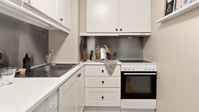 Kjøkkeninnredning med profilerte fronter og laminat benkeplate.