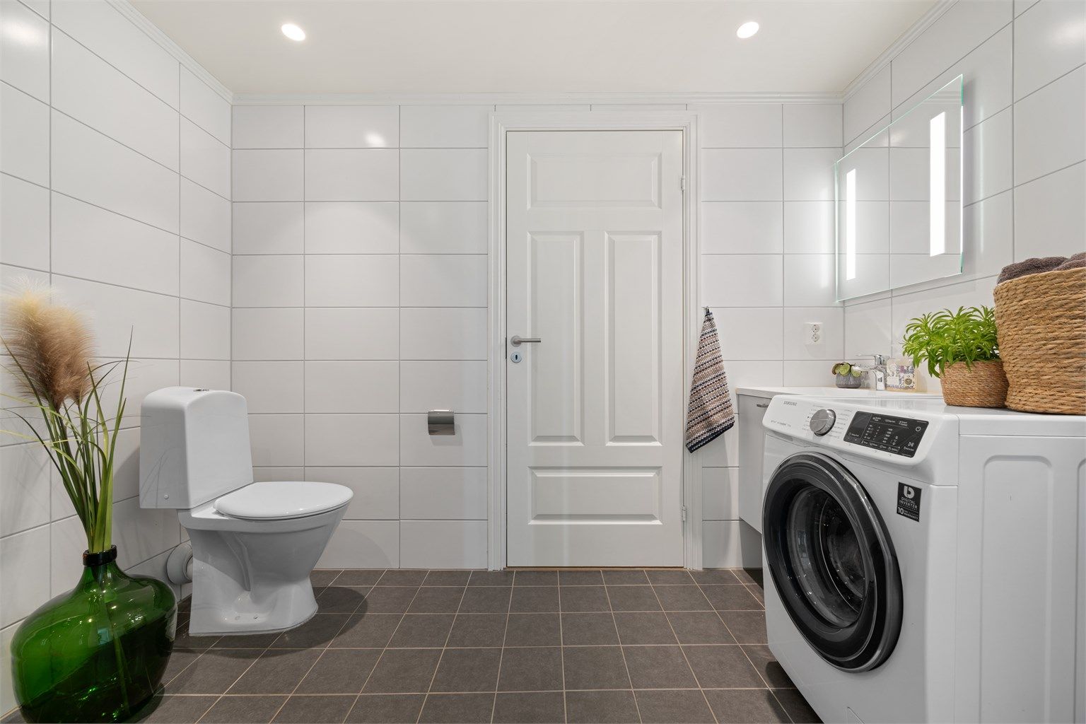 Badet er fra byggeår og har flislagt gulv med elektrisk gulvvarme samt flislagte vegger.