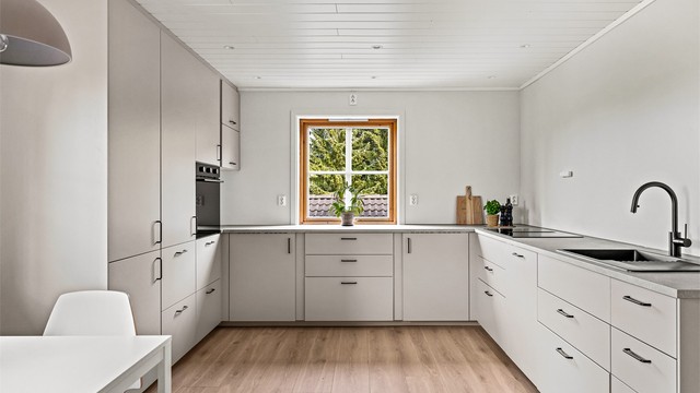 Nytt og moderne kjøkken fra 2026 med glatte fronter og rikelig med skap- og benkeplass.