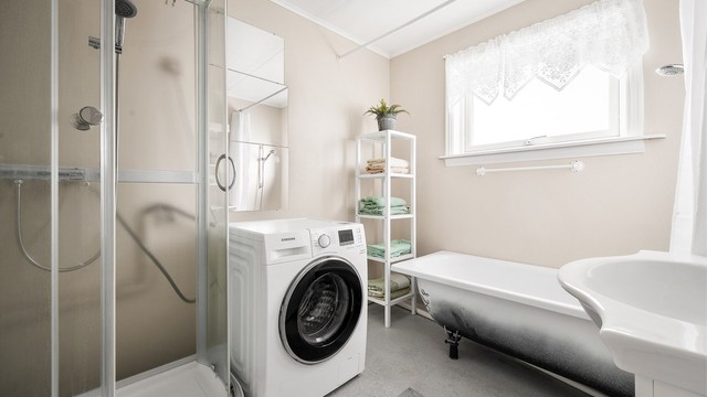 Bad med både badekar og dusjkabinett, og opplegg for vaskemaskin.