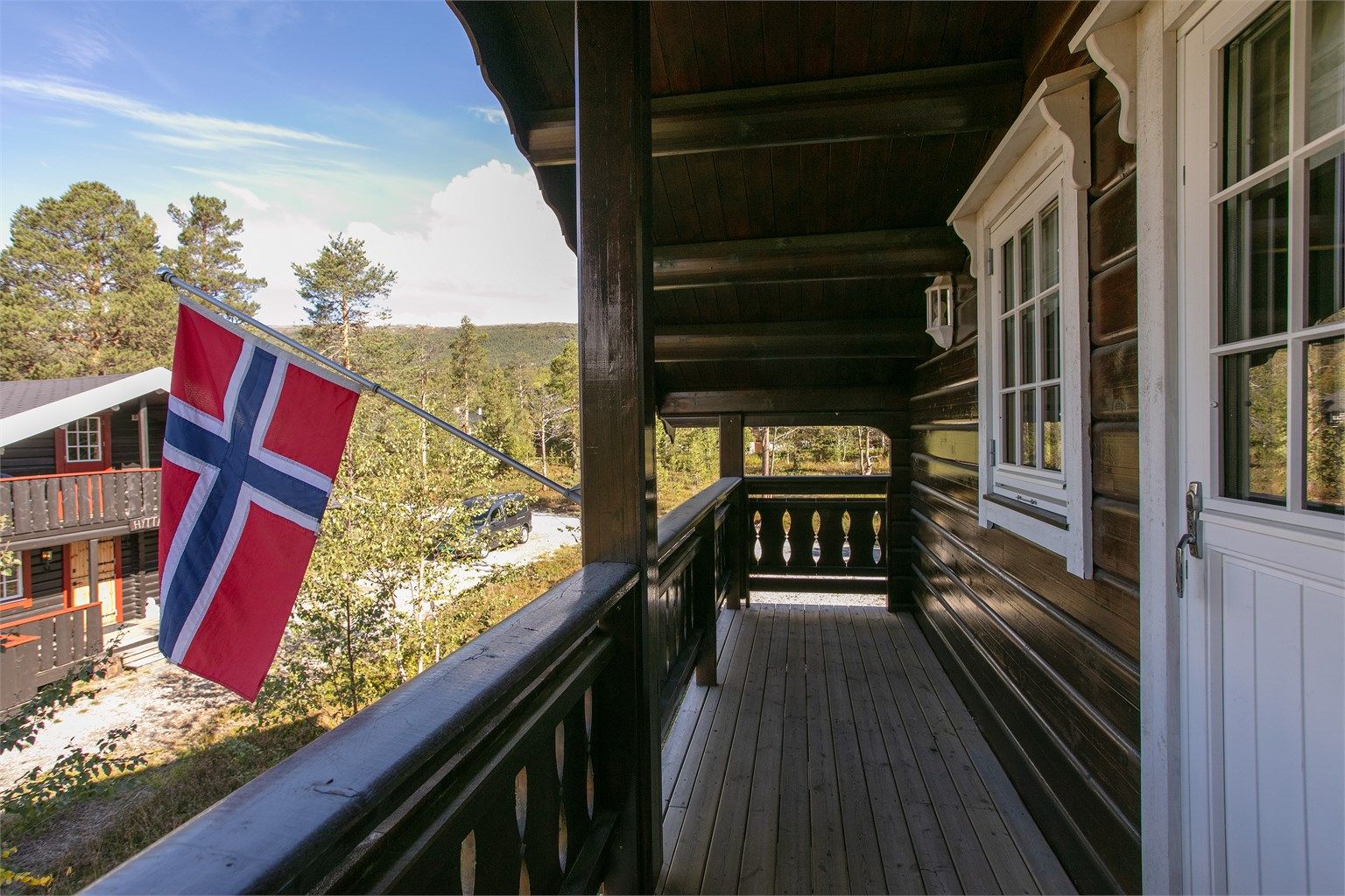 Overbygd balkong i loftsetasjen med utsyn over nærområdet.