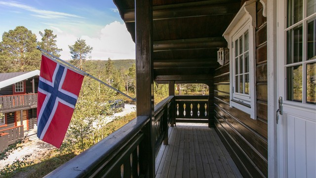 Overbygd balkong i loftsetasjen med utsyn over nærområdet.