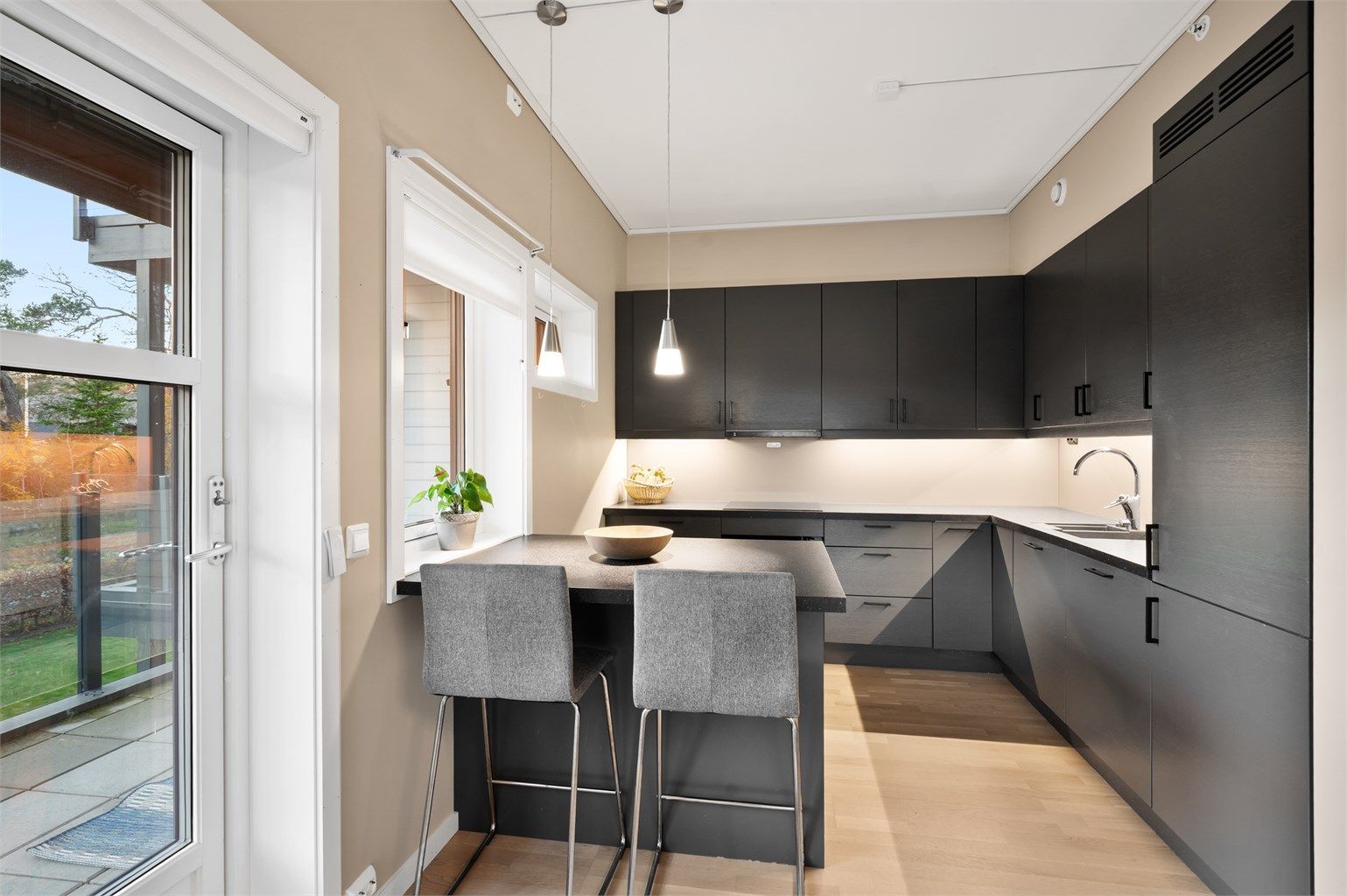 Flott kjøkken med innredning fra Strai og praktisk kjøkkenøy