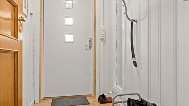 Lys og funksjonell entré med plass til å henge fra seg yttertøy.