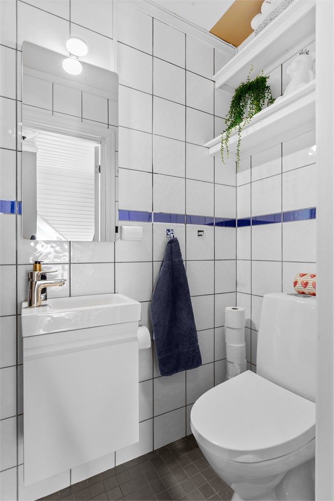 Det andre badet har gulvstående toalett og dusj, praktisk plassert i nærheten av entréen.