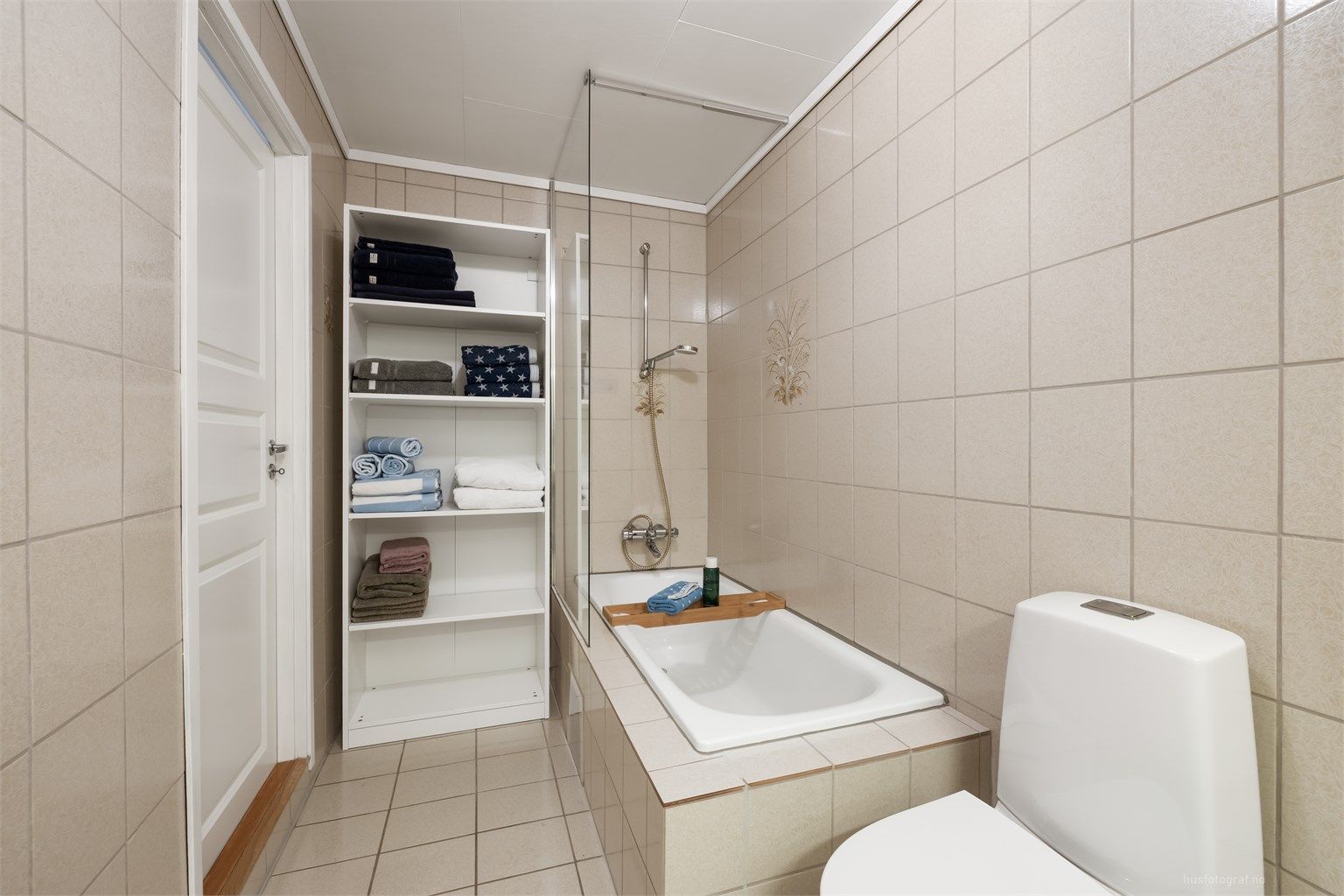 Badet har toalett fra 2022 og innfliset badekar med dusjvegg av glass samt veggmontert dusjarmatur.