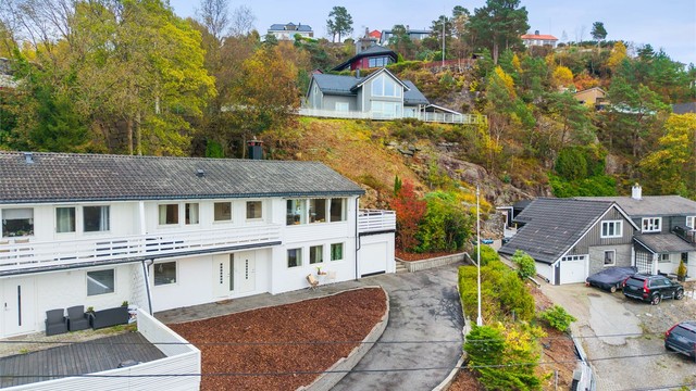 Asfaltert adkomstvei frem til inngangspartiet. Garasje like utenfor døren.