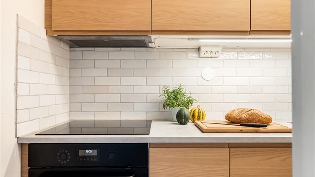 Kjøkkenet har integrert stekeovn, platetopp, oppvaskmaskin og ventilator skjult i overskap.