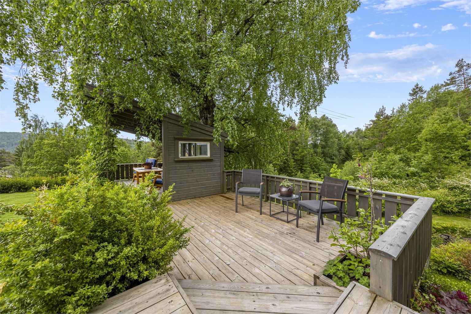 Tomten er opparbeidet med flere treterrasser og soner for uteliv.