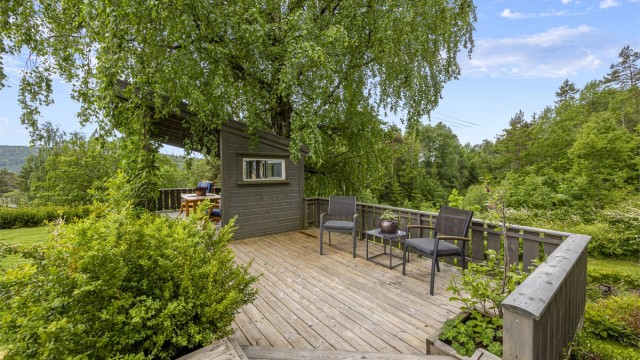 Tomten er opparbeidet med flere treterrasser og soner for uteliv.