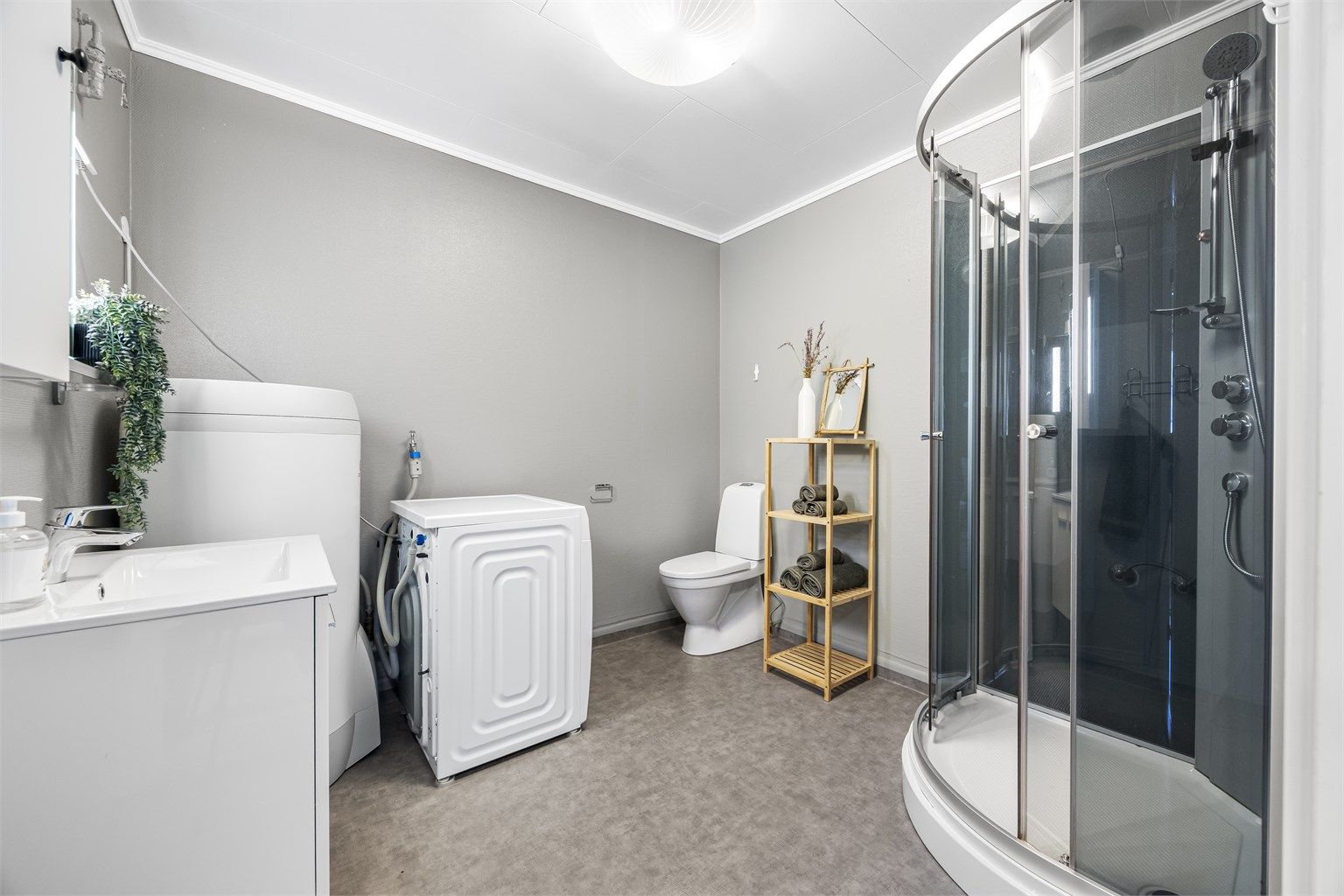Badet har varmekabler i gulvet for økt komfort, og opplegg for vaskemaskin.