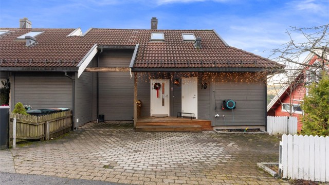 Huset har parkering i garasje og parkeringsmulighet foran huset. Til høyre for inngangsdøren er det en praktisk bod med god largringsplass