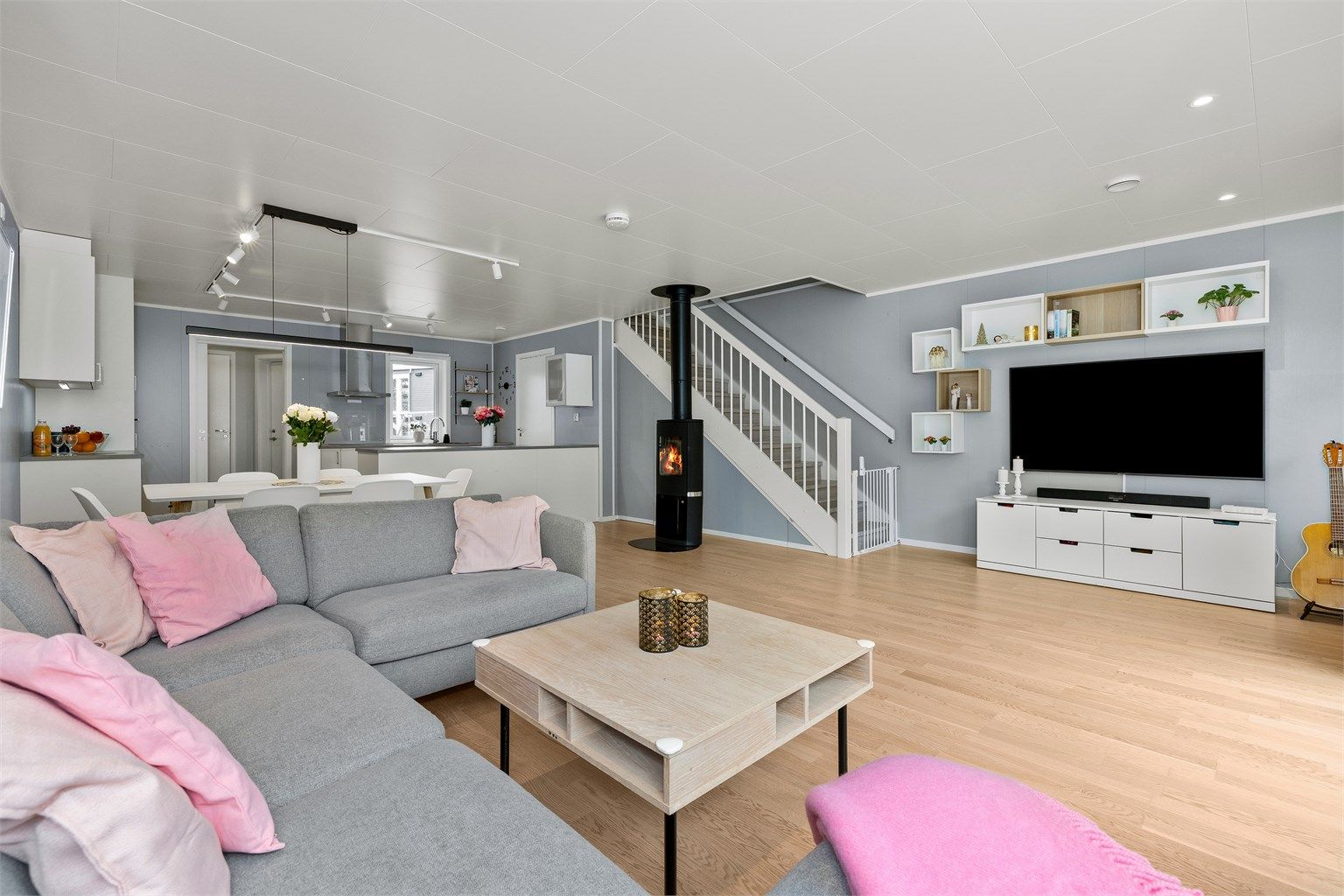 Fin åpen løsning mellom stue og kjøkken som gir god kommunikasjon mellom romdelene. Stilig peisovn som gir lun varme på ekstra kalde dager