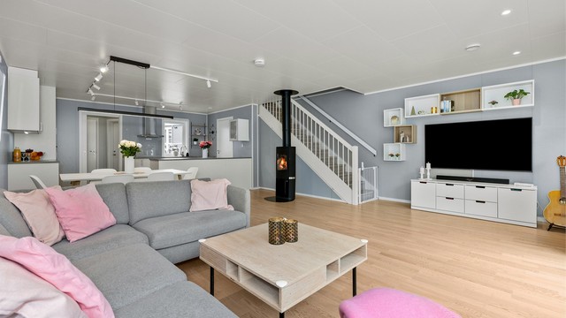 Fin åpen løsning mellom stue og kjøkken som gir god kommunikasjon mellom romdelene. Stilig peisovn som gir lun varme på ekstra kalde dager