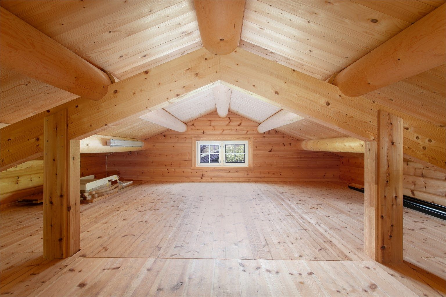 Garasjen har en romslig hems med tregulv og et gulvareal på ca. 33 m² for lagring.