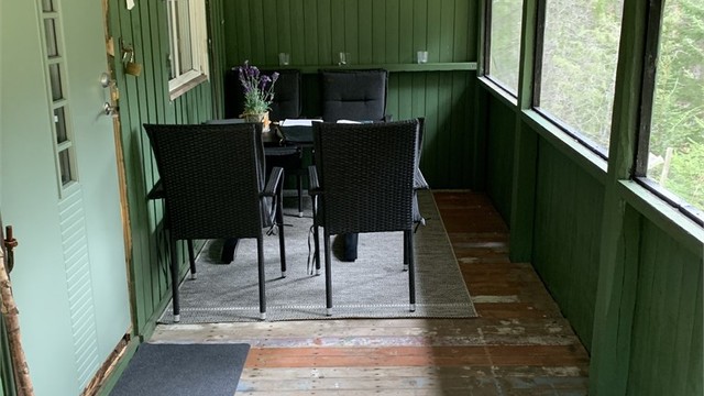 Lun og koselig uteplass under overbygget veranda