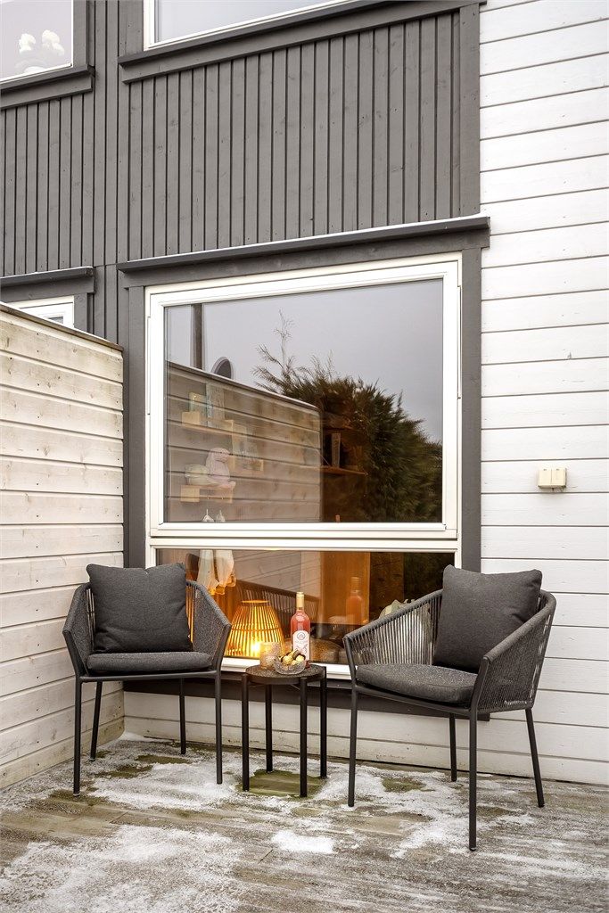 Terrassen er belagt med terrassebord og skjermet med levegger i tre.
