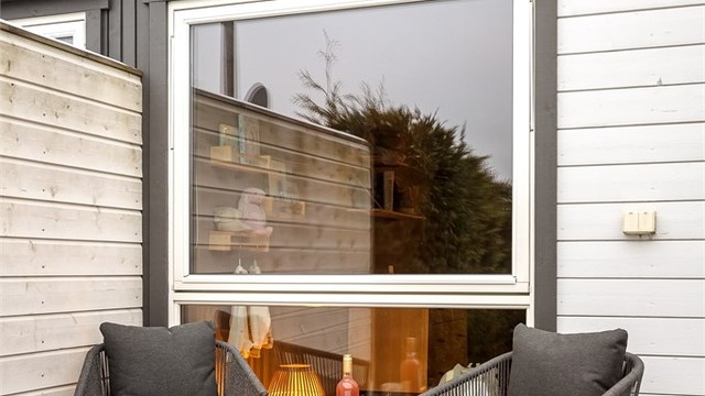 Terrassen er belagt med terrassebord og skjermet med levegger i tre.