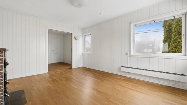 Stuen i andre etasje har parkett på gulvet og malte panelplater på veggene.