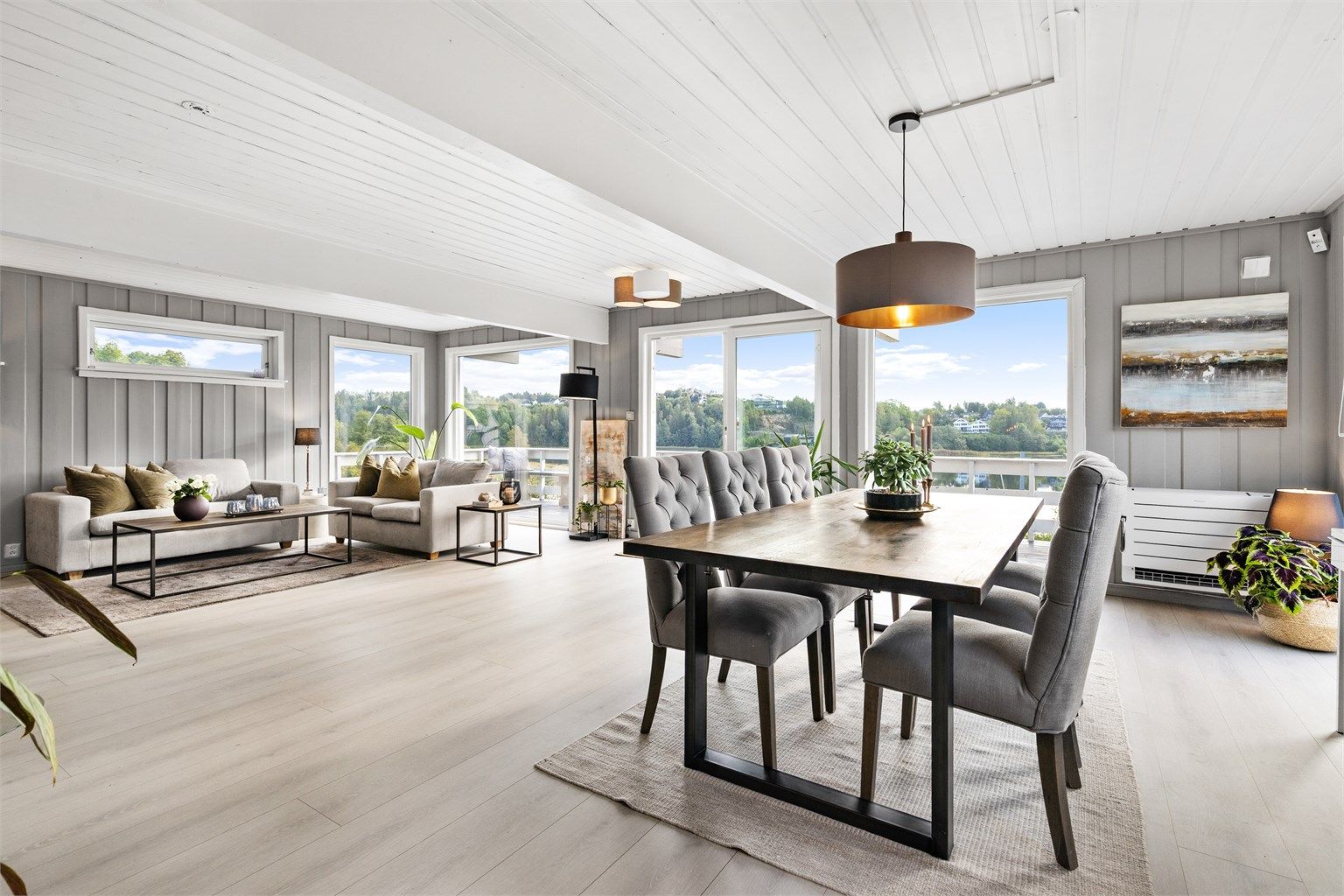Stor lys stue med spisestue, flott utsikt mot Gjellumvannet