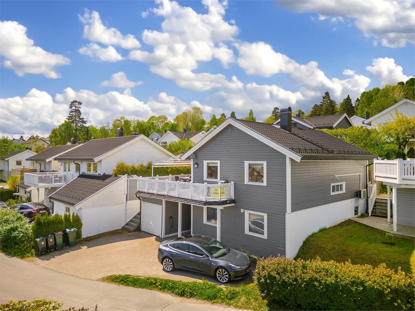 Parkering i integrert garasje med el-billader og disponibel gårdsplass.