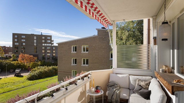 Balkongen har varme tretremmer på dekket og markise fra 2022 som gir behagelig skygge på de varmeste dagene. Herfra har du fri utsikt mot de frodige grøntarealene, et deilig sted å nyte solen i fred og ro.