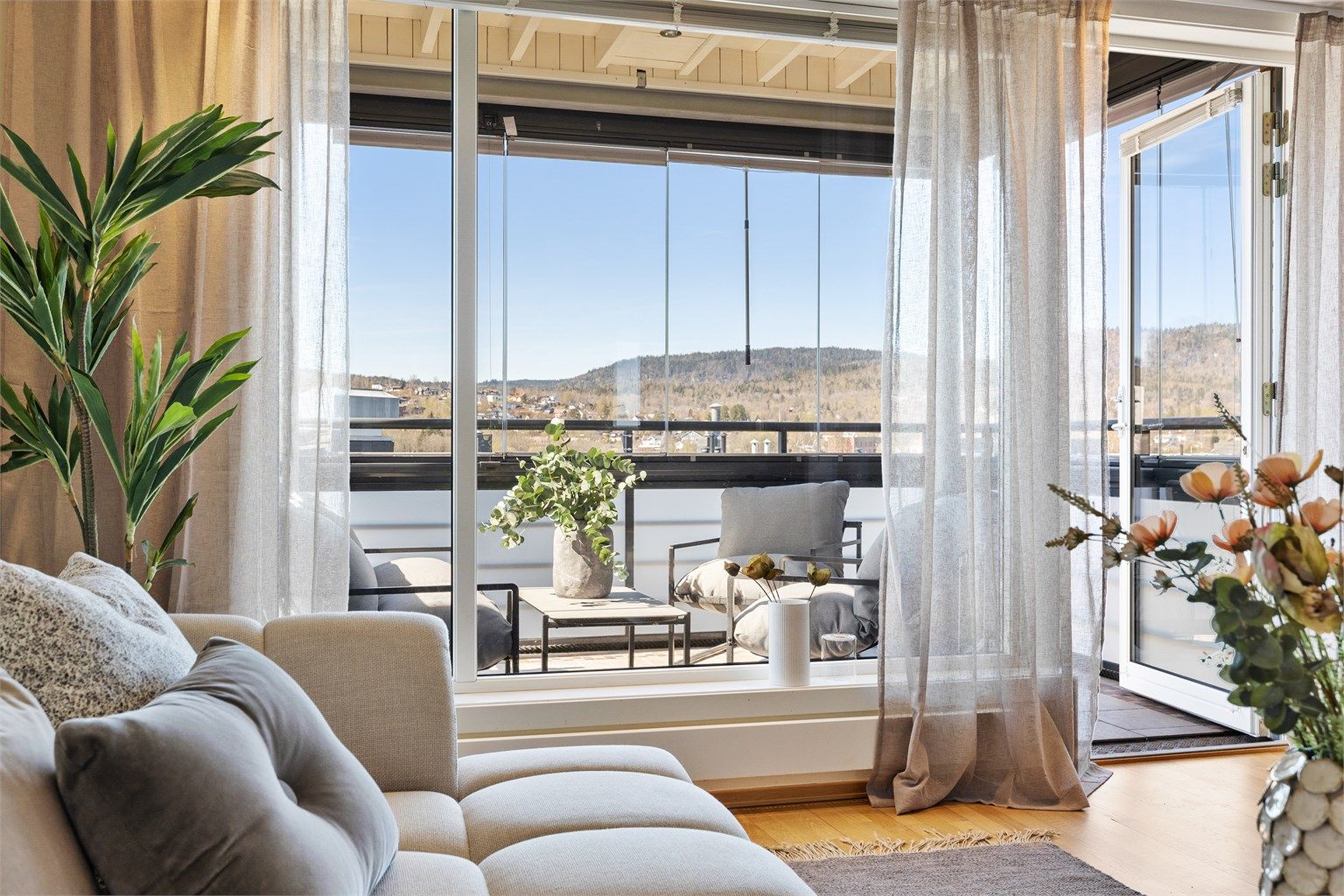 Med store vindusflater føles balkongen som en forlengelse av stuen og skaper en lys og luftig atmosfære. Foto: Trond Reder.