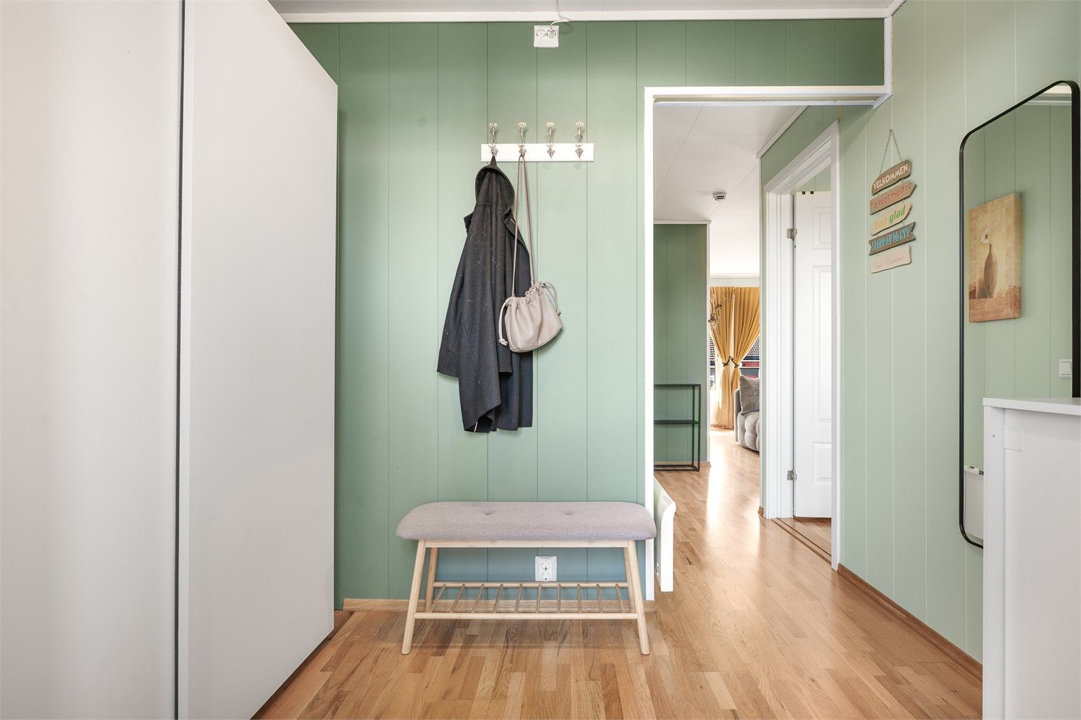 Fra entréen er det direkte tilgang til leilighetens øvrige rom. Veggene har malte panelplater.