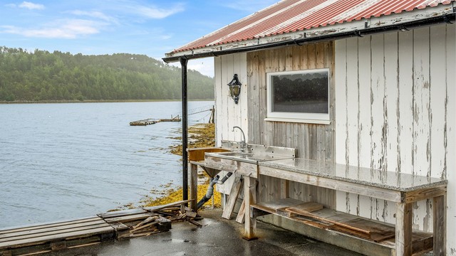 Praktisk sløyebenk ved naustet med vask og god arbeidsflate – perfekt til rengjøring og klargjøring av dagens fangst, med sjøen som nærmeste nabo.