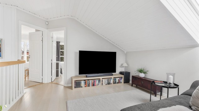 Loftstuen har plass til sittegruppe og TV-område. Herfra er det tilgang til badet og etasjens tre soverom.