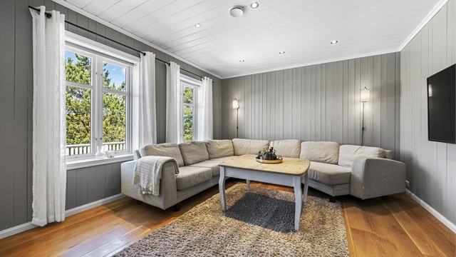 Stuen i hovedetasjen har gjennomgående parkett og plass til en stor sofagruppe.