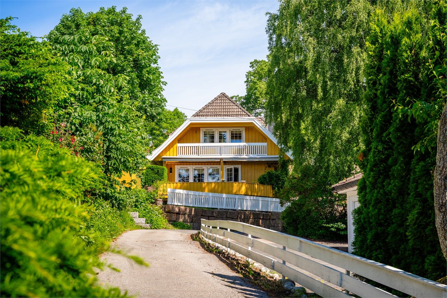 Boligen ligger idyllisk og tilbaketrukket, omgitt av frodig vegetasjon i et veletablert og attraktiv nabolag.