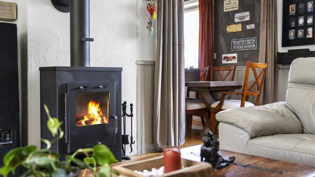 I stuen er det en peis som gir både varme og hygge.
