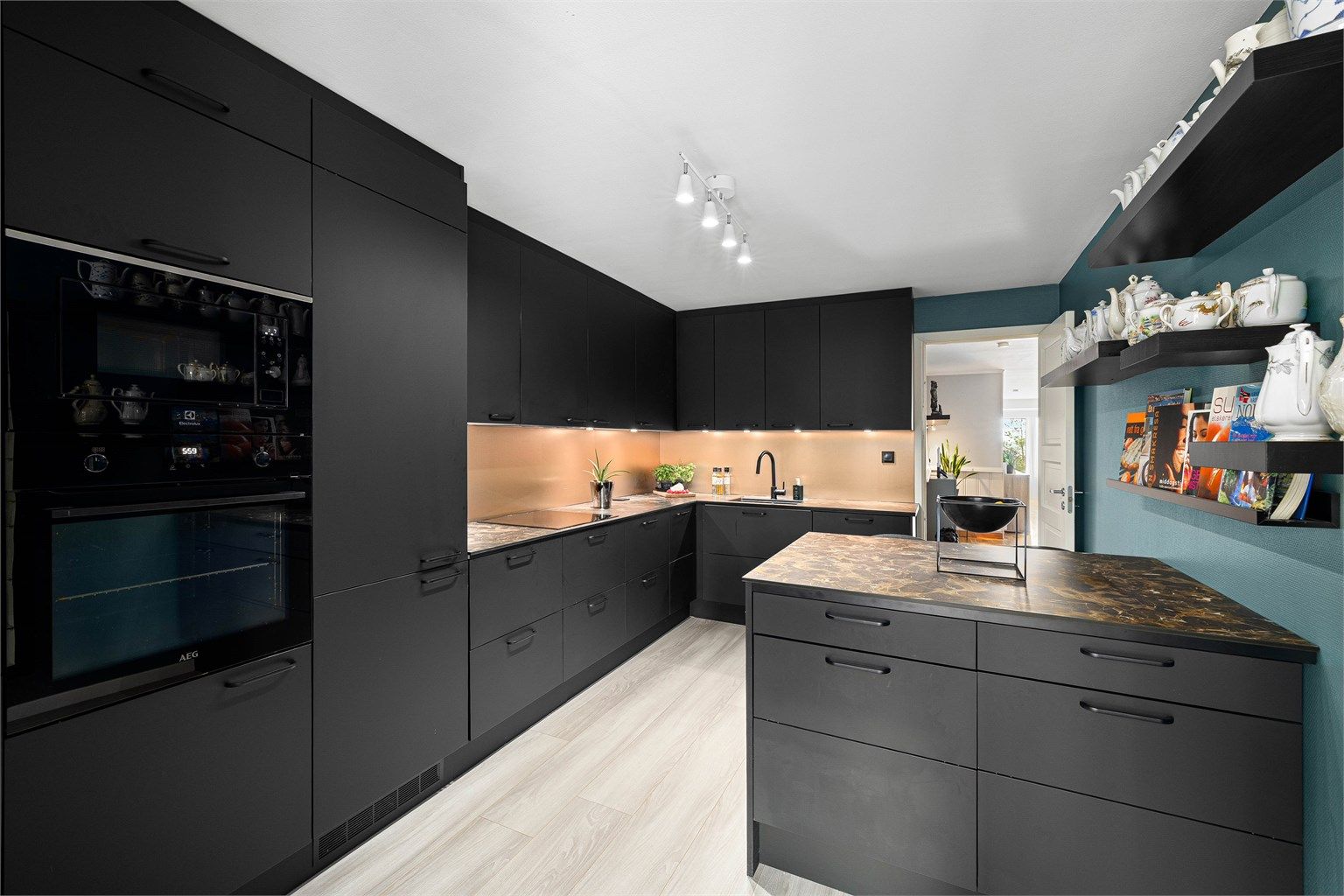 Eksklusivt kjøkken med sorte fronter, integrerte hvitevarer og rikelig med skap- og benkeplass.