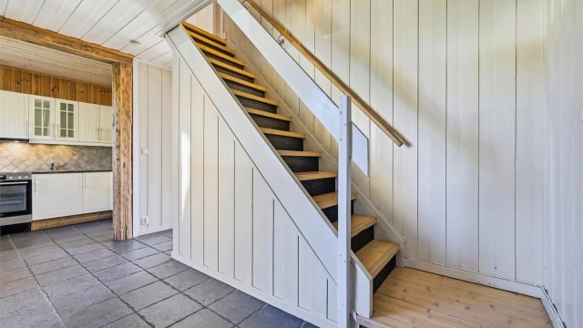 Flislagte gulv i entrè og kjøkken. Vekselpanel på vegger og tak.