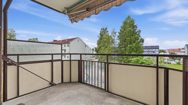 Fra balkongen ser du ut over borettslagets rolige og etablerte fellesområder, sentralt i Lillestrøm.
Foto: Digit Media