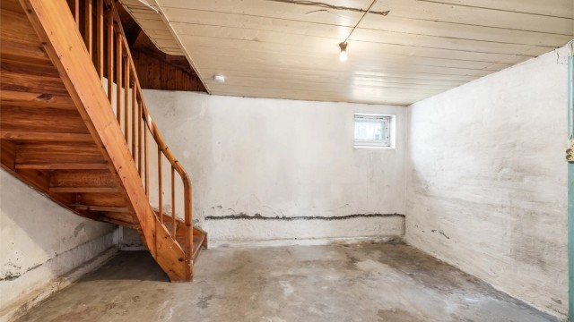 Kjelleren er uinnredet med synlig murgulv og gir rikelig med lagringsplass.