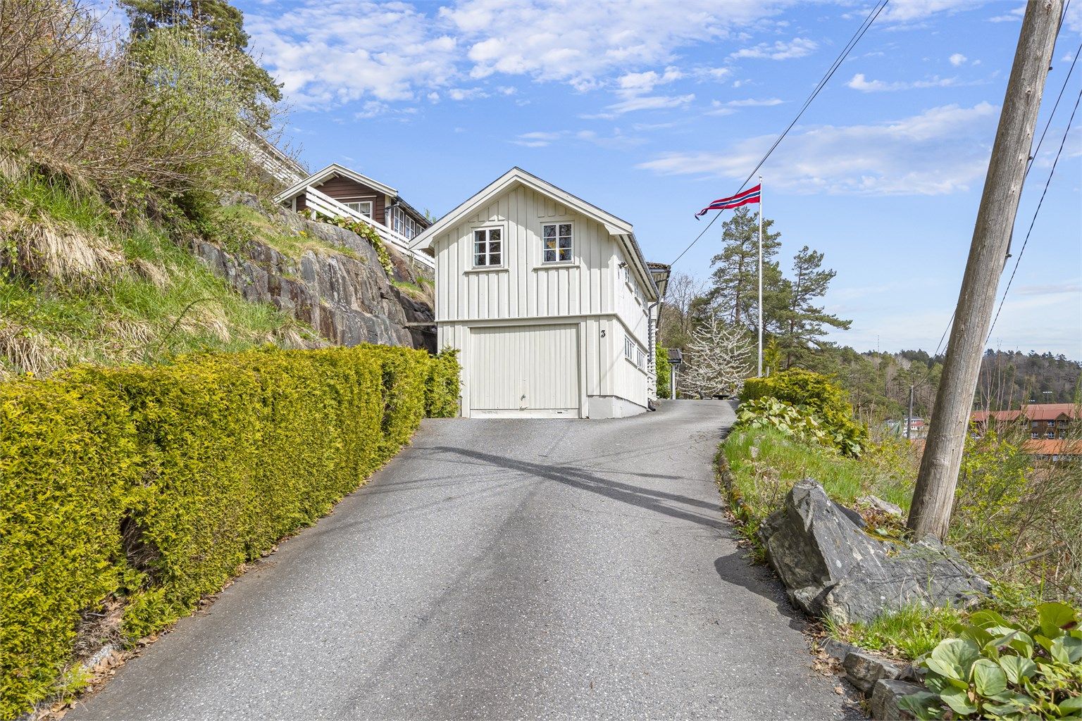 Garasje med lofstue over, asfaltert innkjørsel.