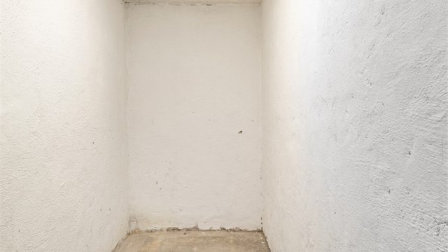 Separat matbod med støpt betonggulv og malte murvegger.