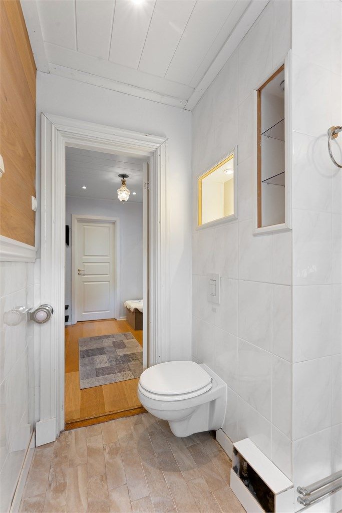 Badet har servantinnredning med ovenpåliggende servant, dusjkabinett, vegghengt toalett og opplegg for vaskemaskin