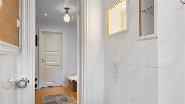 Badet har servantinnredning med ovenpåliggende servant, dusjkabinett, vegghengt toalett og opplegg for vaskemaskin