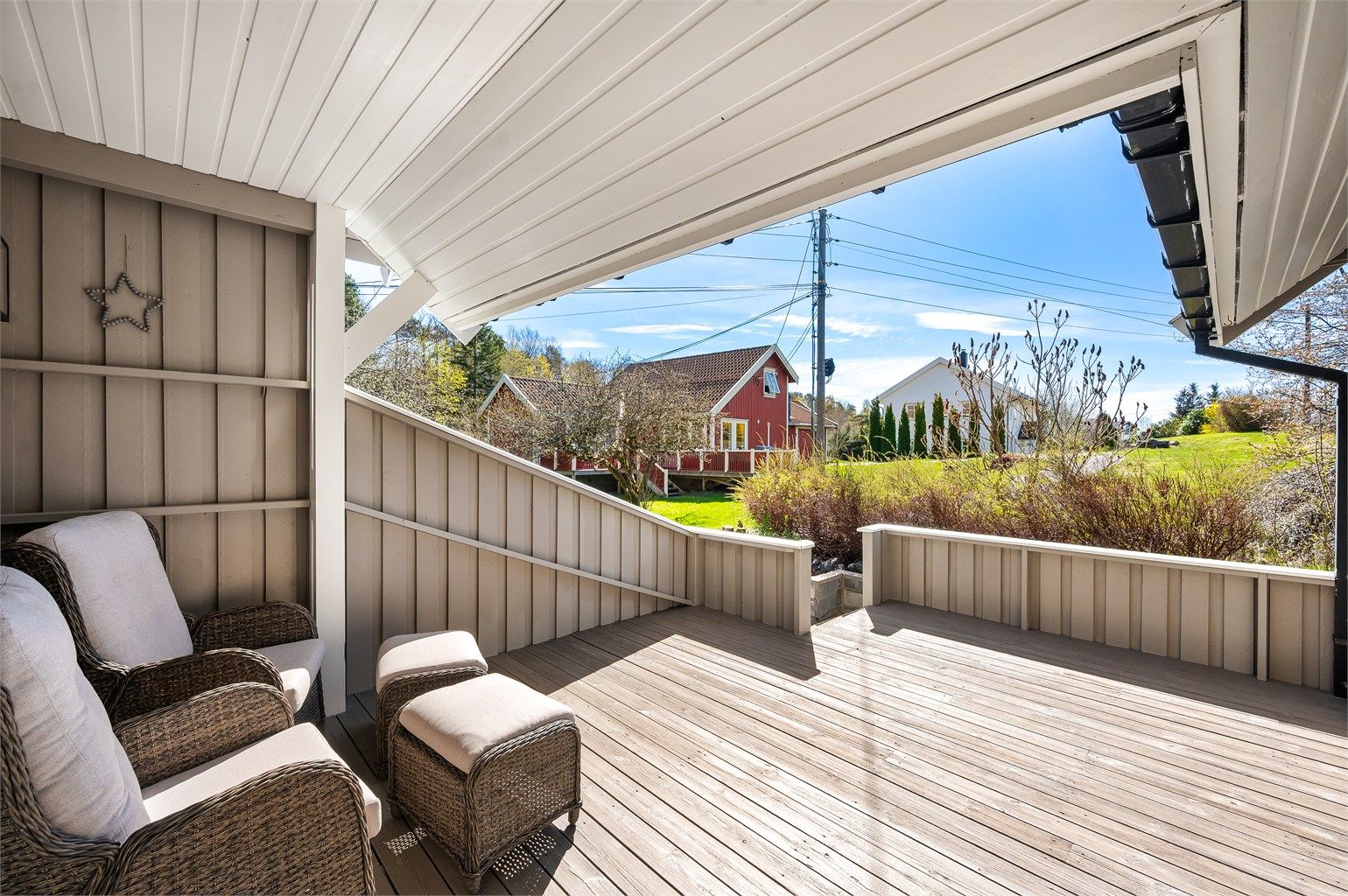 Lun og fin terrasse med delvis overbygg og utsyn utover det omkringliggende landskapet