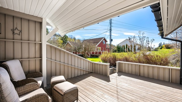Lun og fin terrasse med delvis overbygg og utsyn utover det omkringliggende landskapet