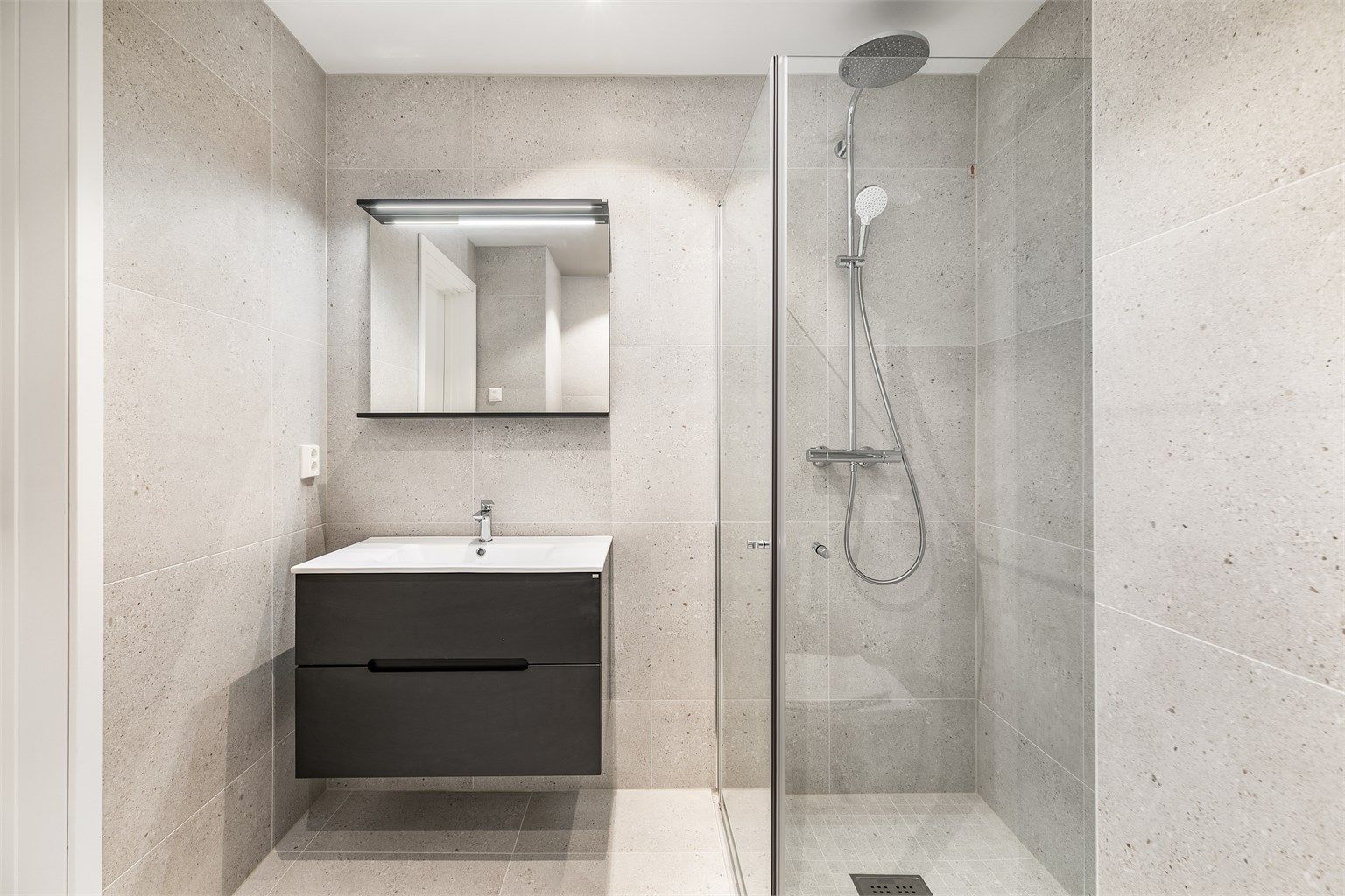Badets gulv og vegger er utført med aktuelle terrazzo-fliser, hovedsakelig i 60x60 cm. format.