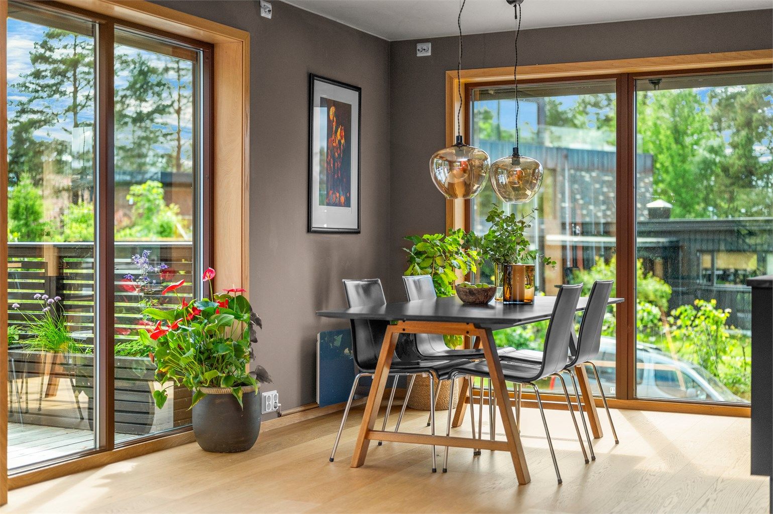 Rikelig med naturlig lys og flere vindusflater skaper en innbydende ramme rundt spiseplassen.