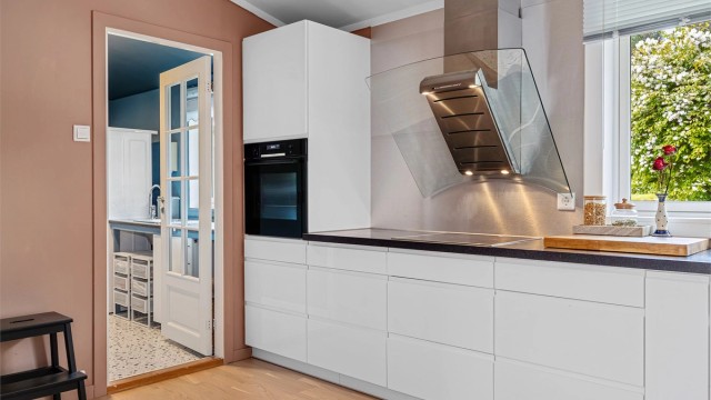 Kjøkkenet er utstyrt med integrert stekeovn, platetopp og vegghengt ventilator.