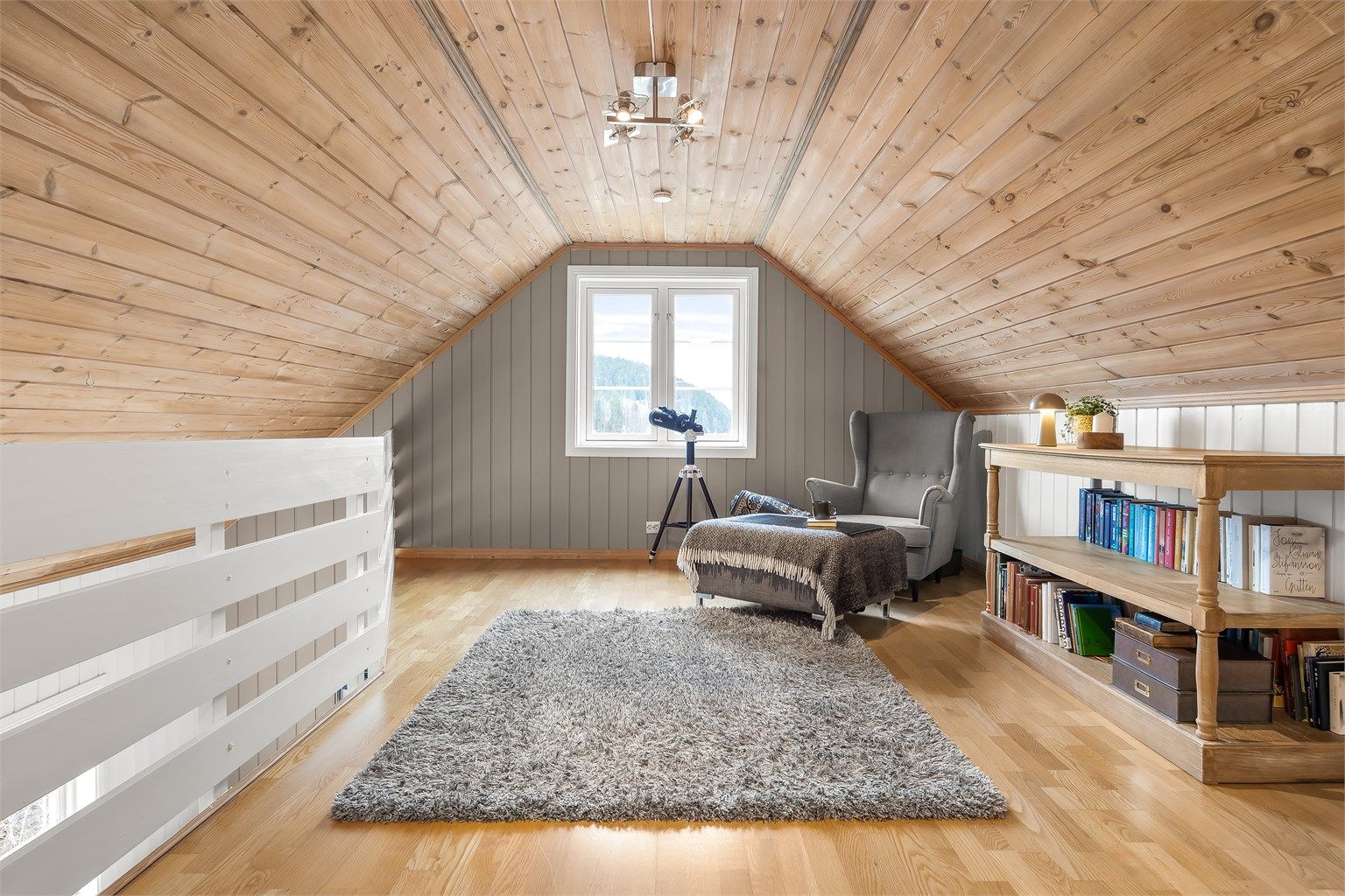 Innredet stue på loftet er lunt og tilbaketrukket med parkett på gulvet og ubehandlet panel i taket. (Det foreligger ikke tegninger av loftet).