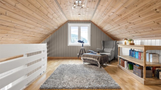 Innredet stue på loftet er lunt og tilbaketrukket med parkett på gulvet og ubehandlet panel i taket. (Det foreligger ikke tegninger av loftet).