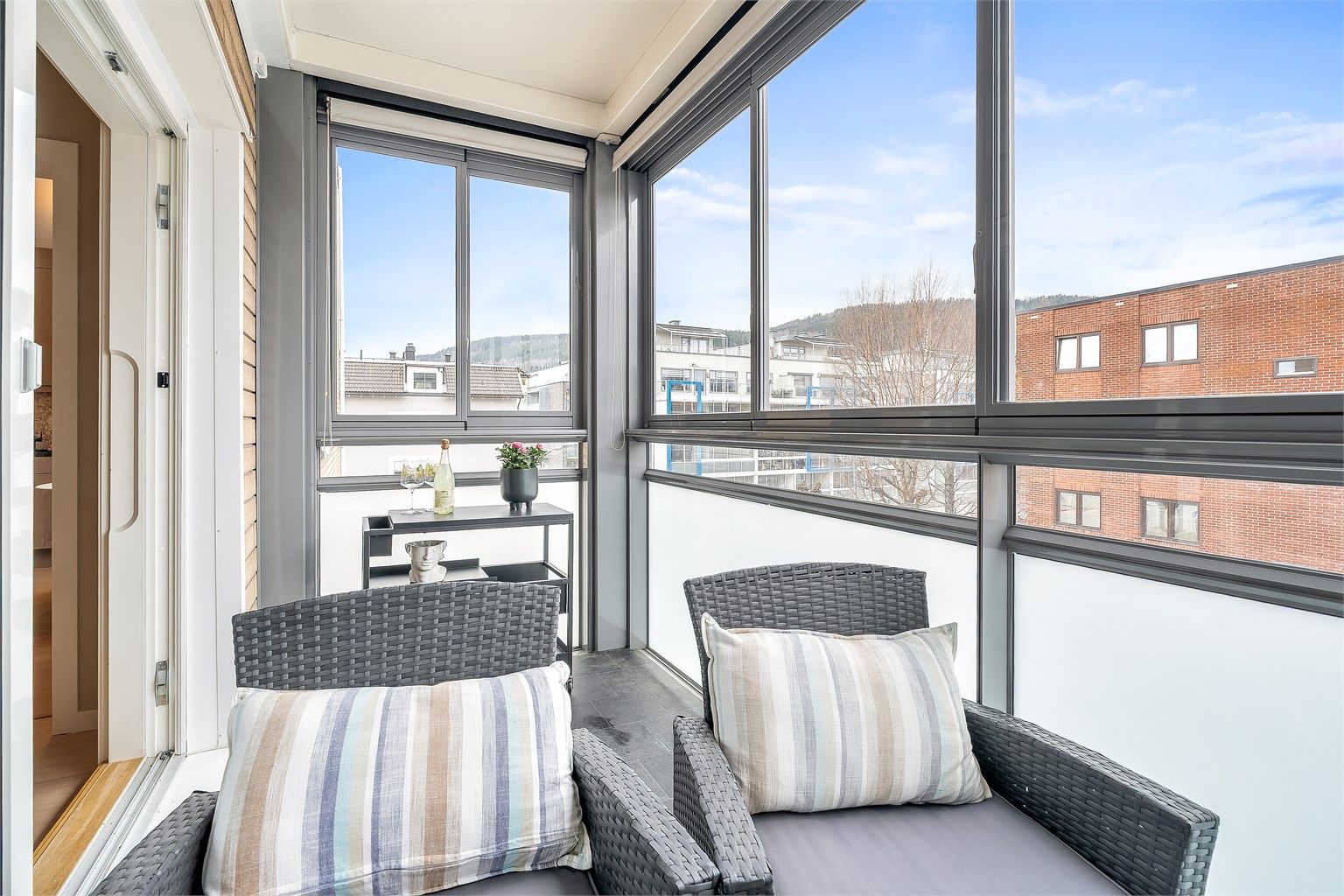 Skyveglassene på balkongen gir fleksibilitet og beskyttelse mot vær og vind, slik at uterommet kan nytes lenger.